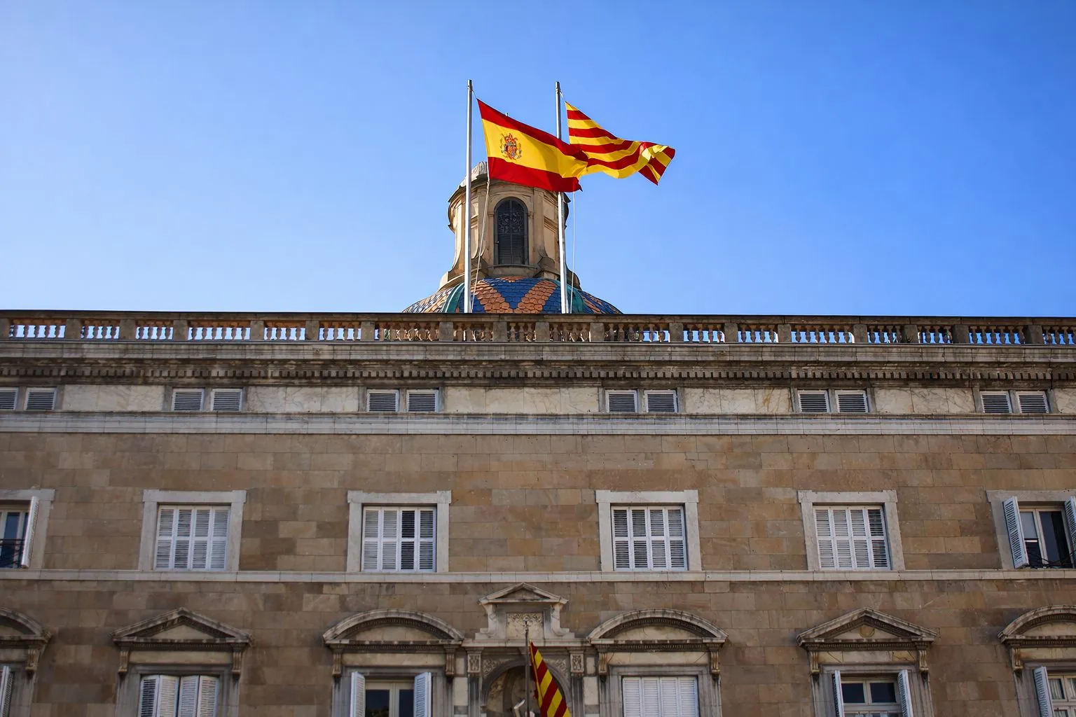 Spanish and Catalan flags flying above the Palau de la Generalitat